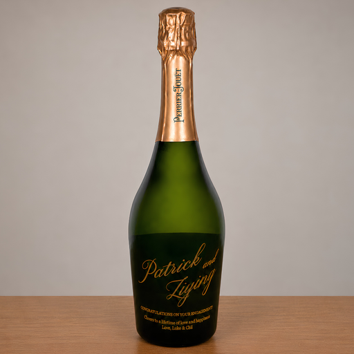 A personalized green glass champagne bottle with a gold foil neck wrap and a custom gold script label reading 'Patrick and Lising' on a wooden surface against a neutral gray background.