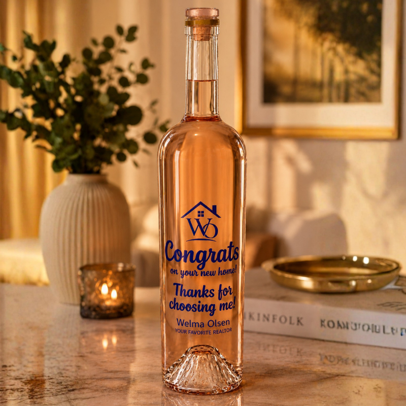 Bottle of rose wine with a personalized label on a table in a cozy room.