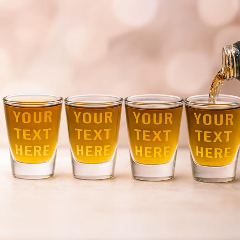 Four shot glasses with 'Your Text Here' text being filled with a liquid.