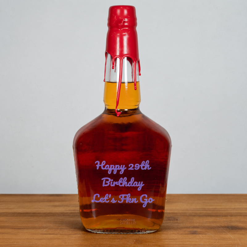 A whiskey bottle with a red wax seal and red wax drips, featuring purple personalized text on the front that reads 'Happy 29th Birthday Let's Flex Go', set on a wooden surface against a light gray background.