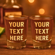 Two shot glasses with 'Your Text Here' text on a wooden surface.