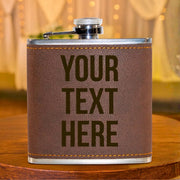 Brown leather flask with 'YOUR TEXT HERE' text on a wooden surface.