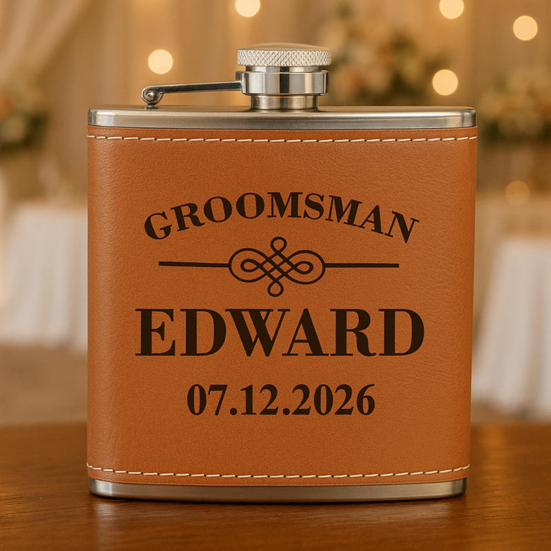 Brown leather flask with 'Groomsman Edward 07.12.2026' engraving on a wooden surface.