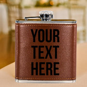 Brown leather flask with 'YOUR TEXT HERE' text on a blurred background
