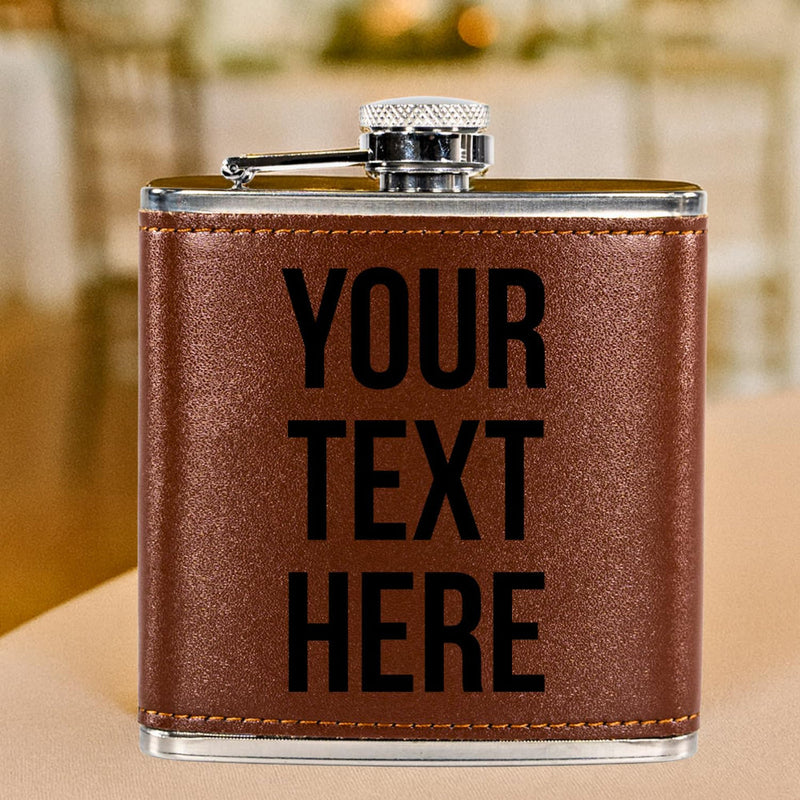 Brown leather flask with 'YOUR TEXT HERE' text on a blurred background