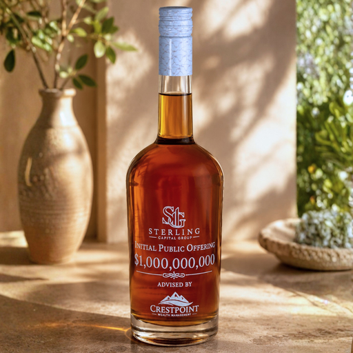 Bottle of Sterling Initial Public Offering on a wooden surface with decorative plants in the background