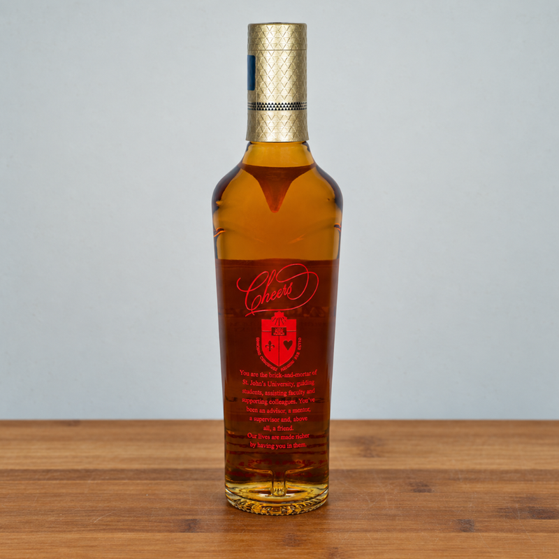 A bottle of macallan 12 with amber liquid, a red label, and a gold cap, standing on a wooden surface against a light gray background.