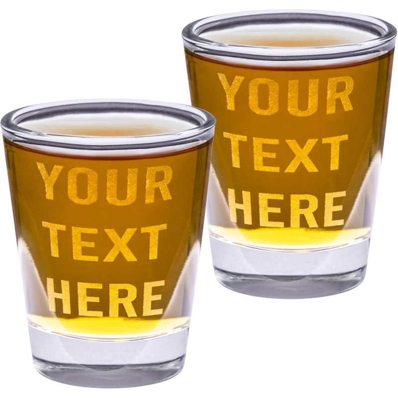 Two shot glasses with 'Your Text Here' text printed on them, filled with a yellow liquid.